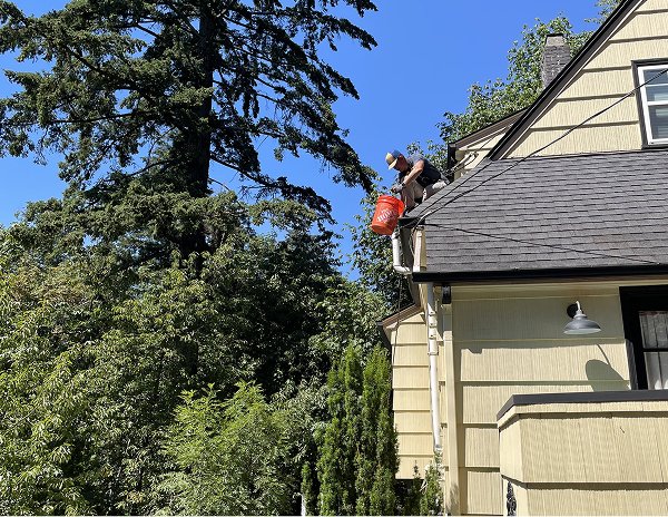 expert-cleaning-gutter-with-bucket